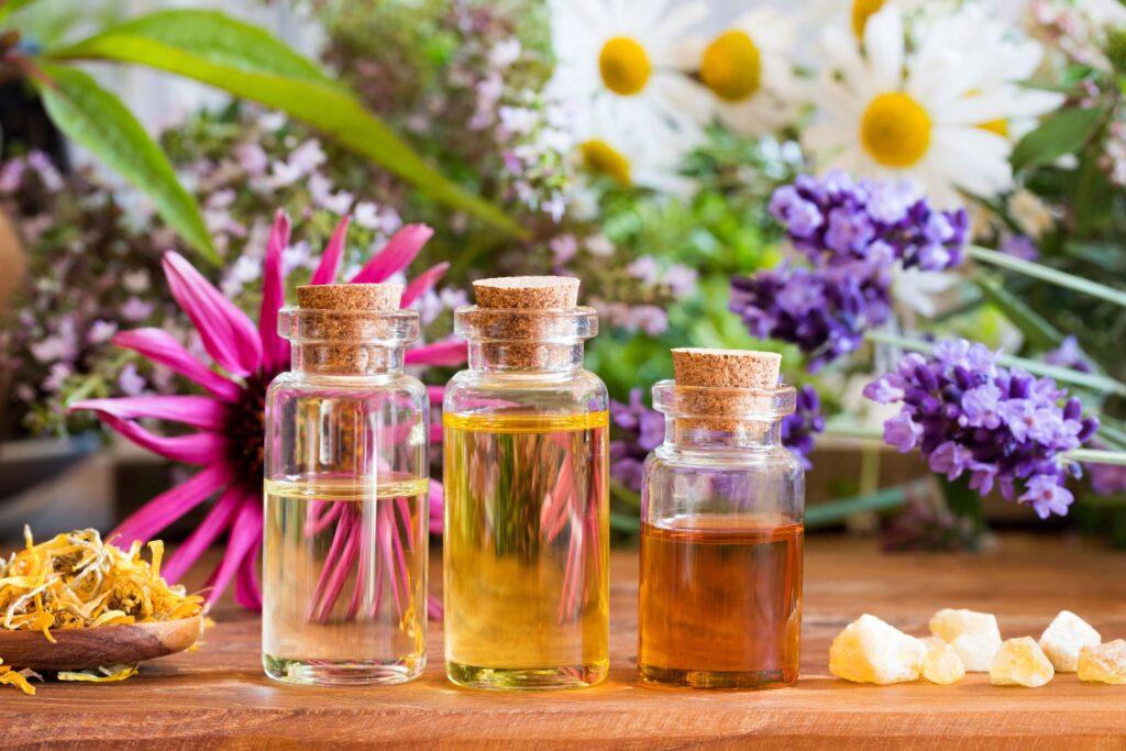 Essential oils in small bottles with flowers in the background